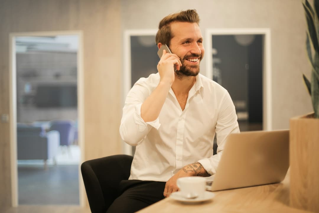 Happy business professional working at desk with modern technology